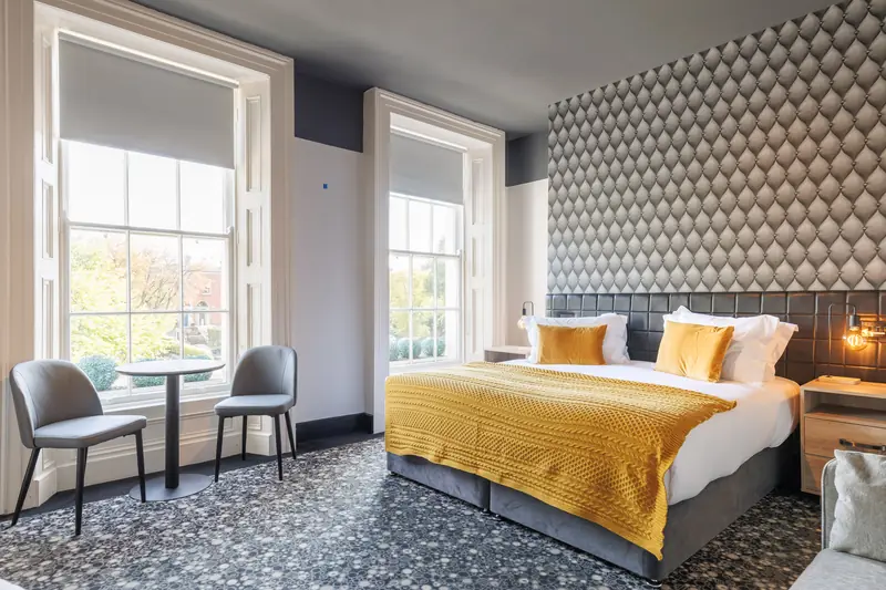 A Deluxe Double room with a super king bed and two tall sash windows