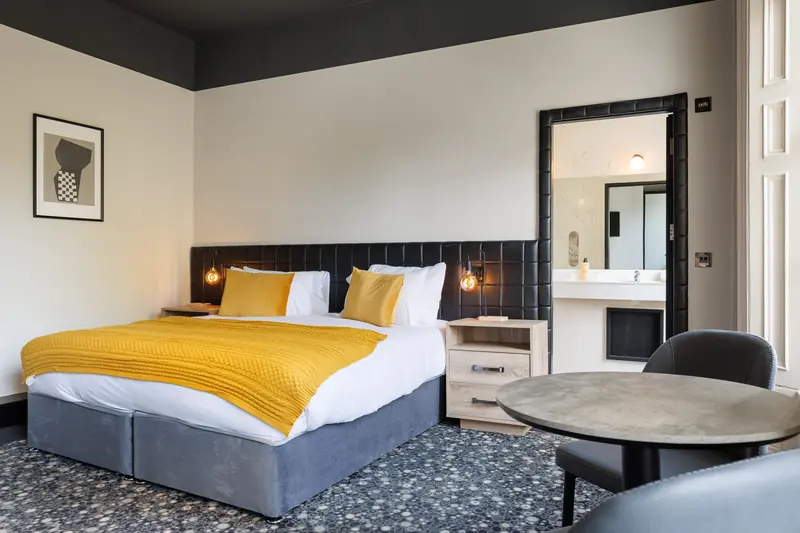 A Superior Double room with a super king bed and a small round table