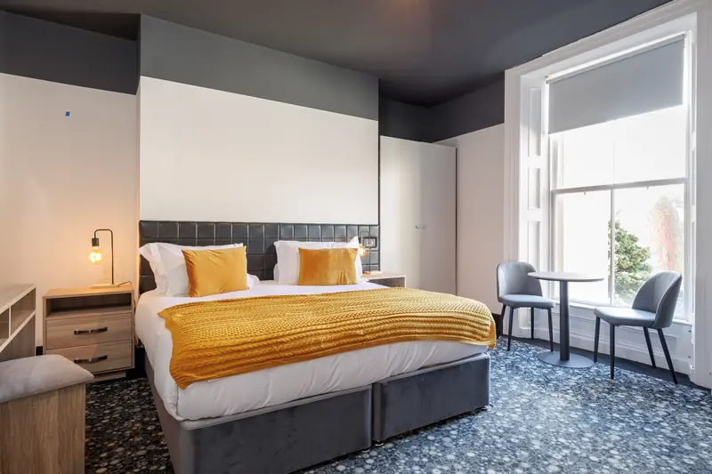 A Superior Triple room with a super king bed and a window onto the trees