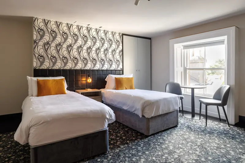 A Superior Twin room with two single beds and a table by the window